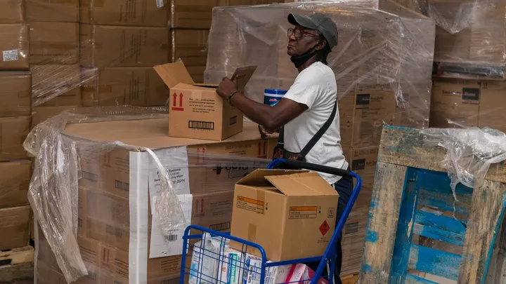 Worker sorting boxes of PPE in a warehouse